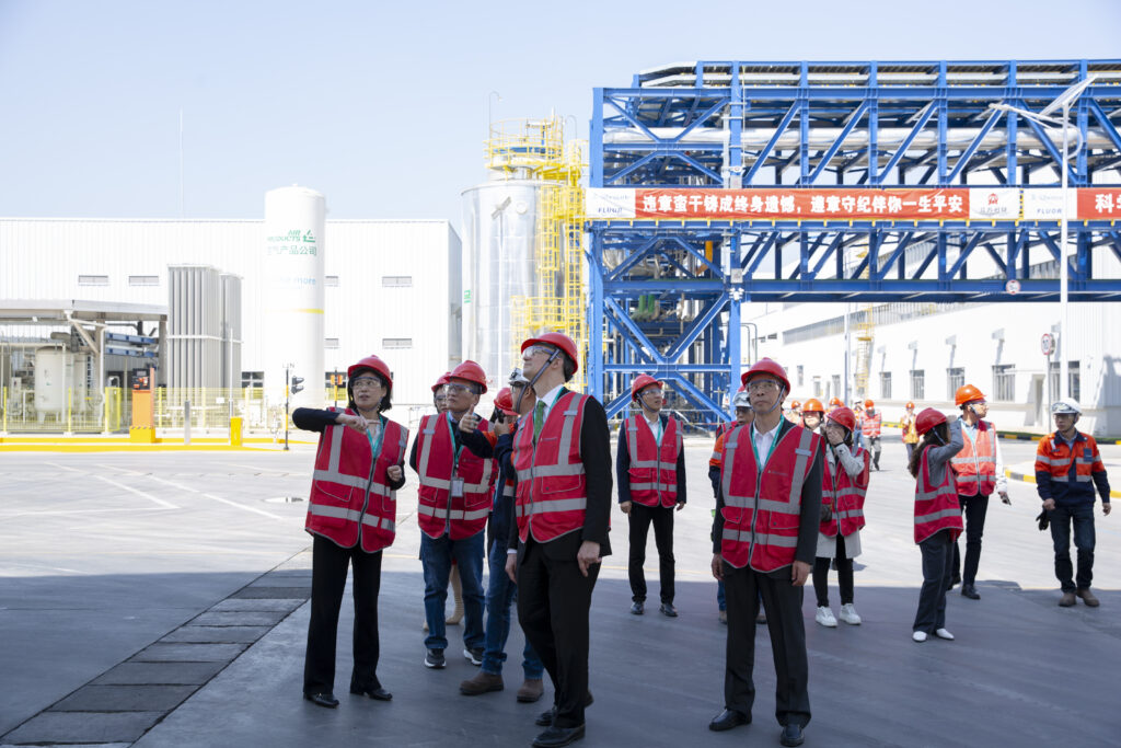 China factory tour — professional guide inspecting production line with client